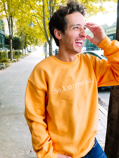Guy laughing in gold sweatshirt